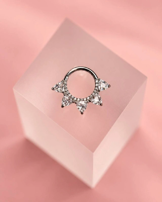 Украшение из коллекции Rose Gold на розовом фоне — фотография студии.